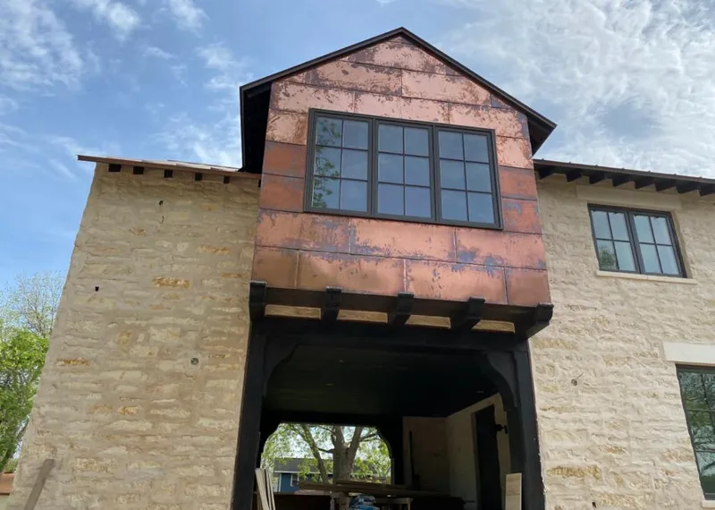 Copper metal panel facade on a stone building for Roof Repair in Bonadelle Ranchos